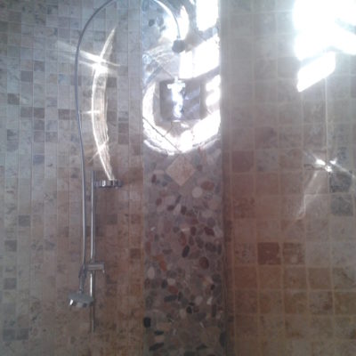 Mur de douche en galet et travertin (marbre)
